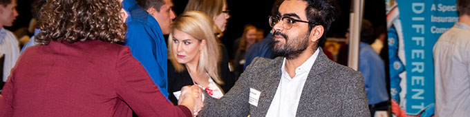 People shaking hands at a networking event.